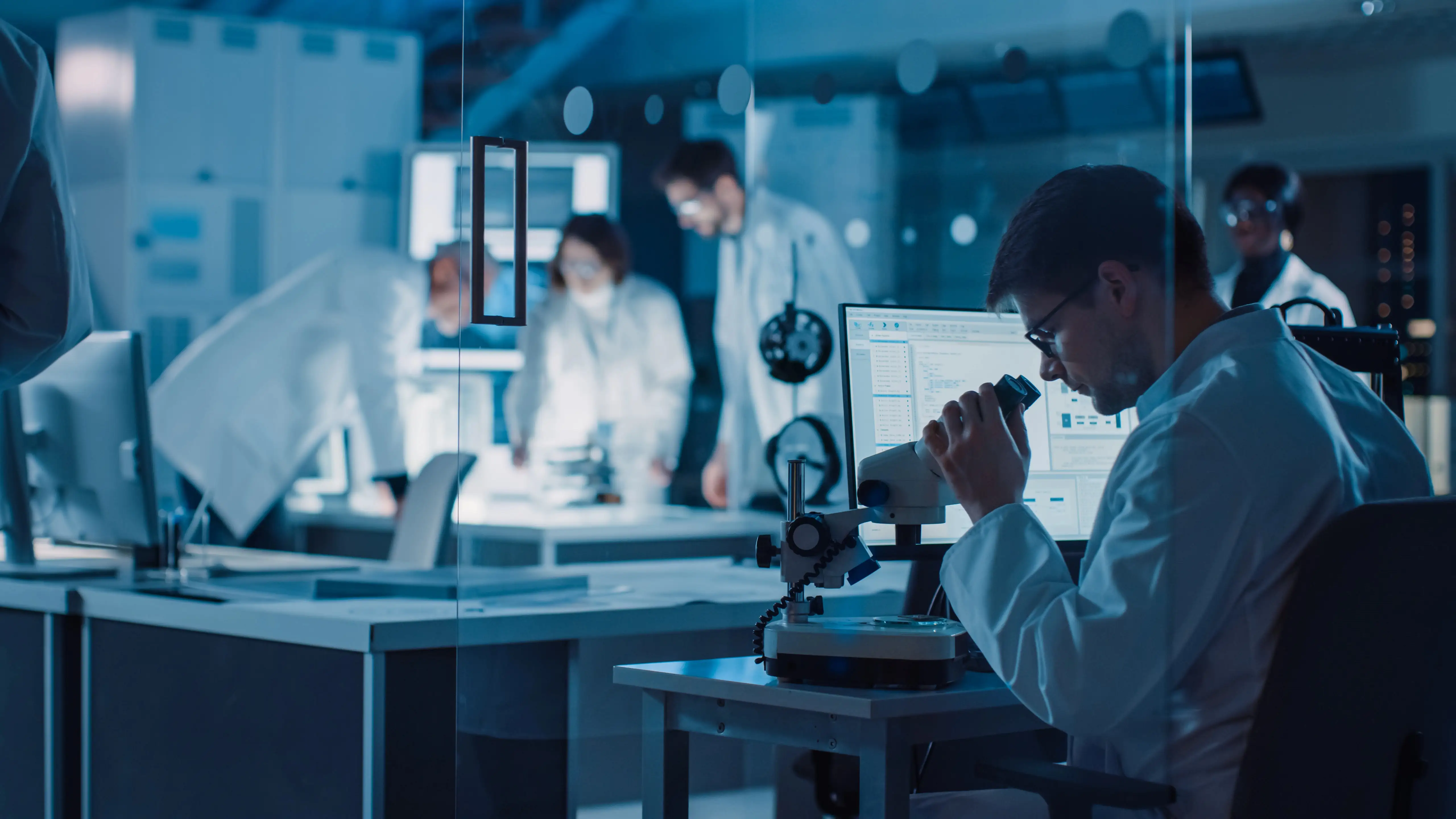 Scientist analyzing with a high-tech microscope blood samples and molecular visualizations