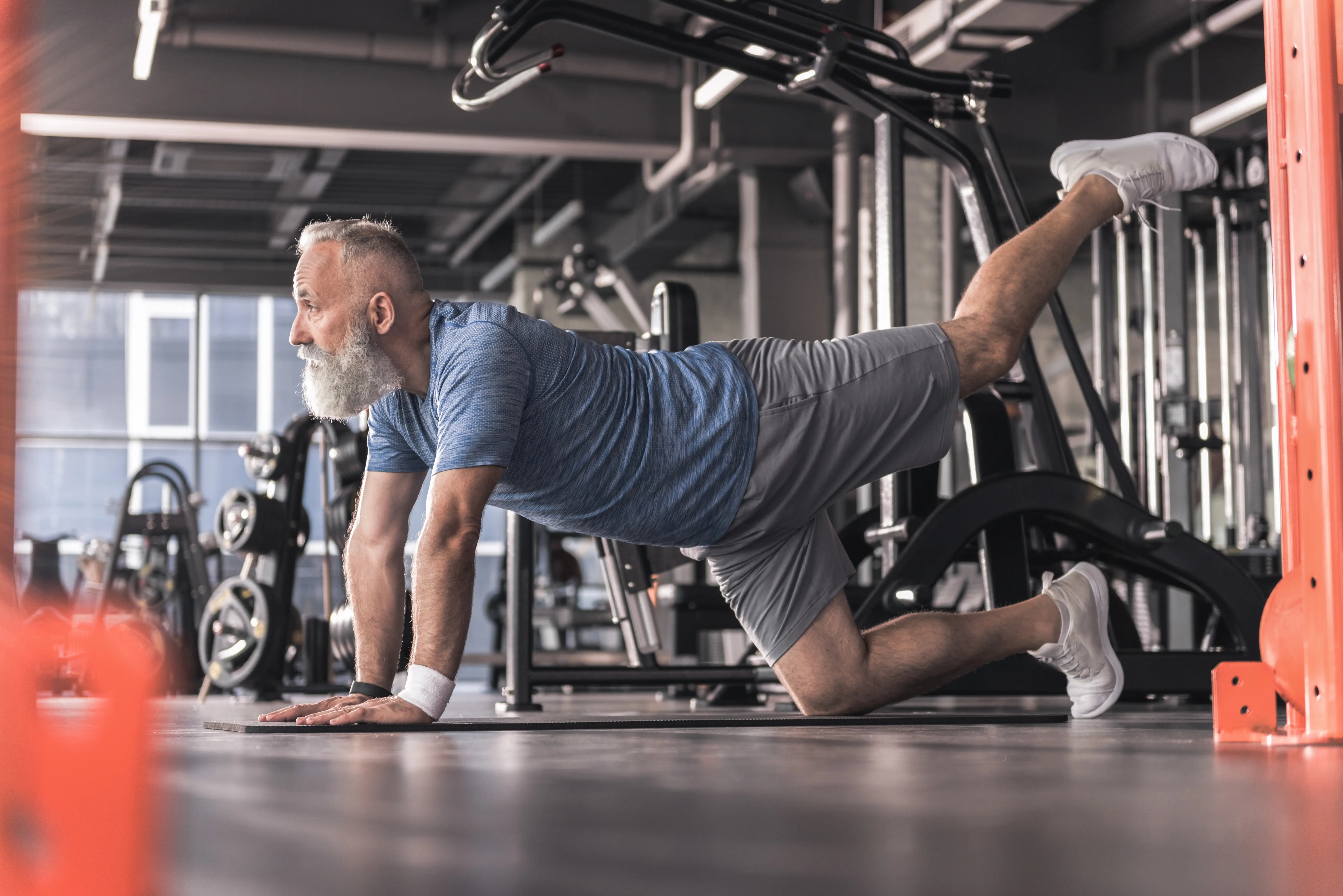 Hombre mayor de 50 años haciendo ejercicio en gimnasio - longevidad saludable y envejecimiento activo